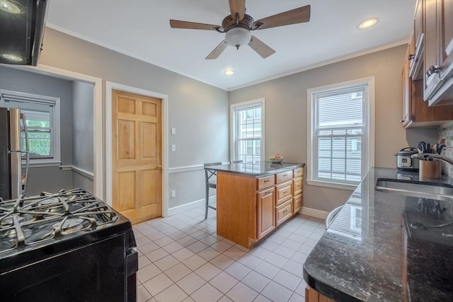 56 Marlboro St Unit 1, Belmont, MA 02478 - kitchen with black gas stove, freestanding refrigerator, a sink, light tile patterned floors, and brown cabinetry