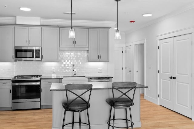 kitchen with gray cabinets, light hardwood / wood-style floors, appliances with stainless steel finishes, and sink