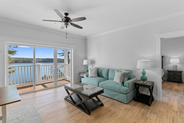 living room featuring ceiling fan, crown molding, a water view, and light hardwood / wood-style floors