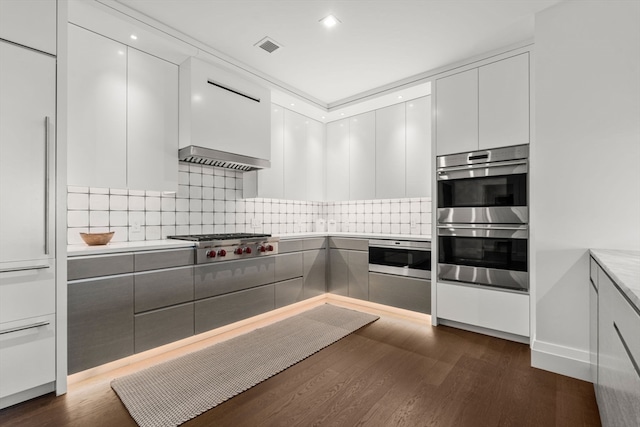 kitchen with stainless steel appliances, tasteful backsplash, and dark wood-type flooring