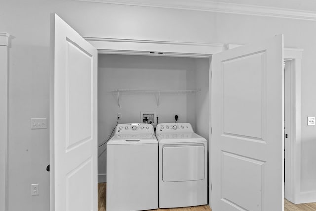 clothes washing area with washer hookup, hookup for an electric dryer, crown molding, light hardwood / wood-style flooring, and washing machine and dryer