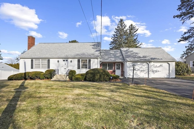 view of front of house featuring a front lawn, driveway, a shingled roof, a garage, and a chimney