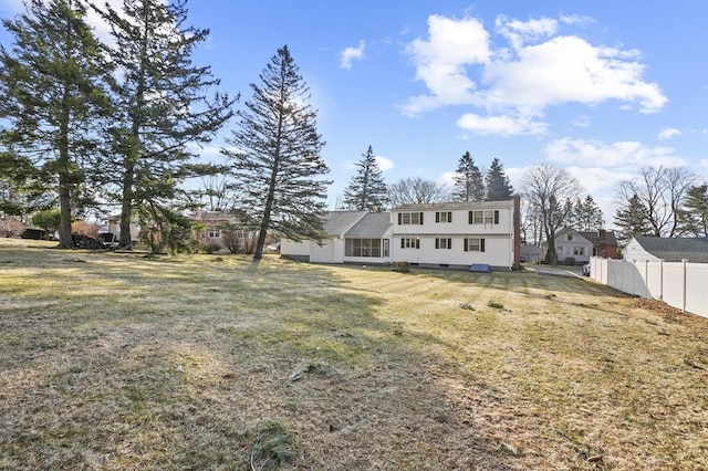 rear view of property with a yard and fence