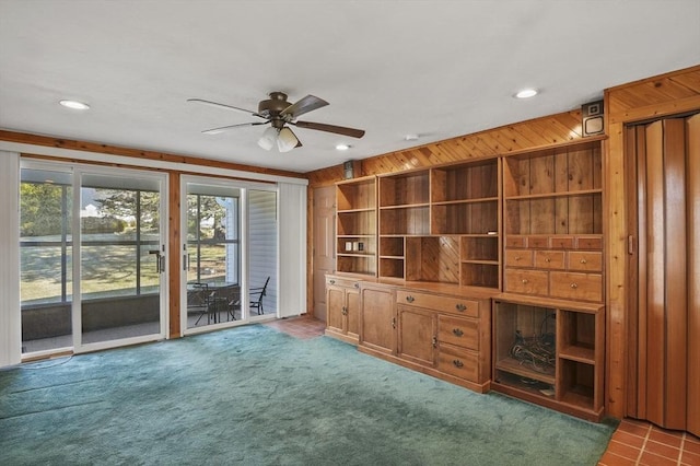 unfurnished living room featuring recessed lighting, carpet, wood walls, and ceiling fan