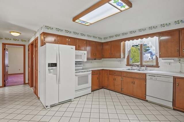 kitchen featuring white appliances, light countertops, tasteful backsplash, and a sink