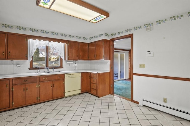 kitchen featuring a baseboard radiator, a sink, decorative backsplash, light countertops, and dishwasher