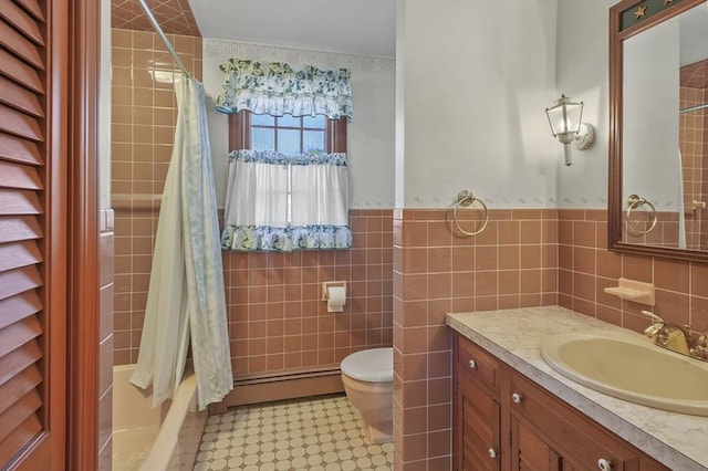 bathroom with toilet, tile walls, wainscoting, a baseboard radiator, and vanity