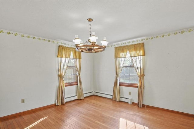 empty room with baseboard heating, baseboards, light wood-style floors, and an inviting chandelier