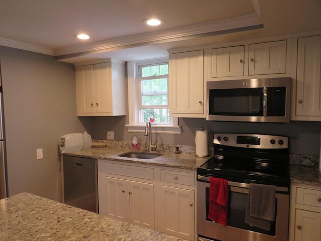 82 Main St, Blackstone, MA 01504 - kitchen featuring stainless steel appliances, ornamental molding, a sink, white cabinetry, and light stone counters