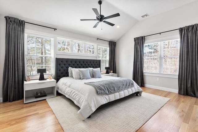 bedroom with light wood-type flooring, multiple windows, visible vents, and vaulted ceiling