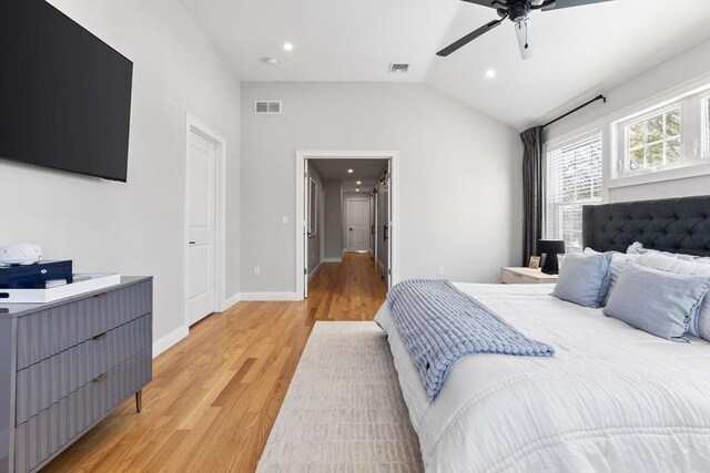 bedroom with lofted ceiling, baseboards, visible vents, and light wood-style floors