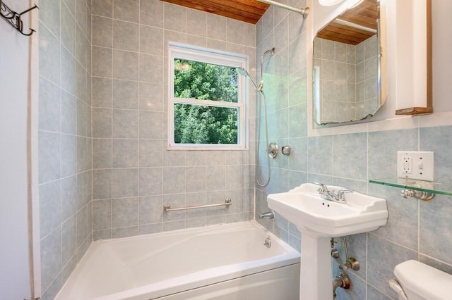 bathroom with tile walls, shower / tub combination, toilet, and backsplash