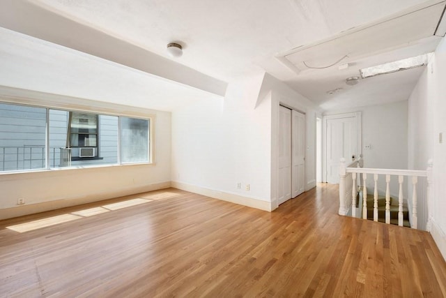 unfurnished room with light wood-type flooring and baseboards