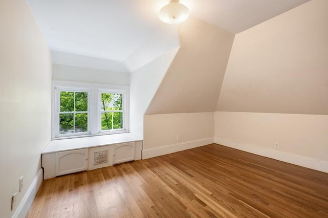 bonus room with wood finished floors and baseboards
