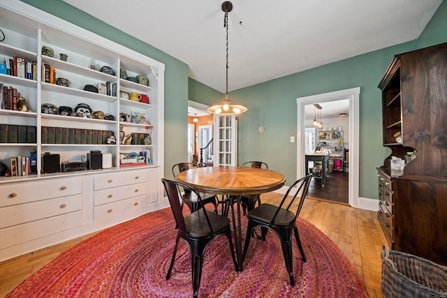 dining space featuring wood-type flooring and an inviting chandelier