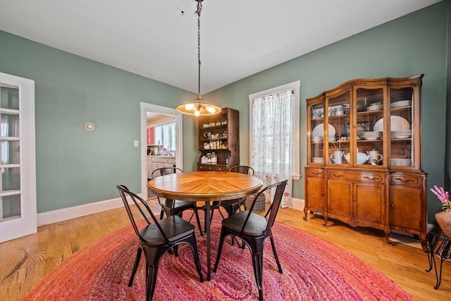 dining area featuring baseboards and light wood-style floors