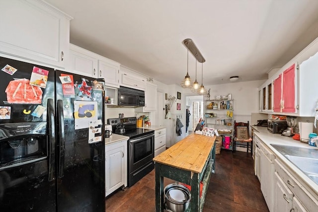 kitchen with white cabinetry, black appliances, and hanging light fixtures