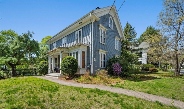 view of side of home featuring fence and a yard