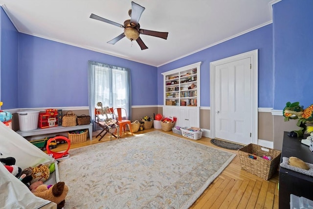 game room featuring a ceiling fan, wood finished floors, and ornamental molding