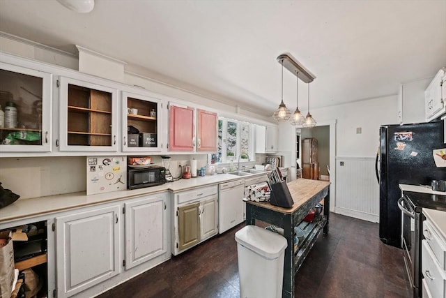kitchen featuring black microwave, wainscoting, dishwasher, light countertops, and electric stove