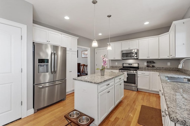 131 Great Rd, Shirley, MA 01464 - kitchen with appliances with stainless steel finishes, white cabinetry, a center island, light wood finished floors, and recessed lighting