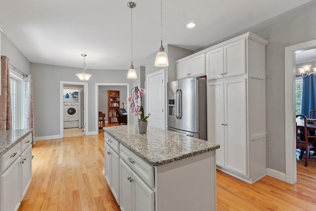 131 Great Rd, Shirley, MA 01464 - kitchen featuring stainless steel fridge with ice dispenser, washer / dryer, light wood-style floors, and white cabinetry
