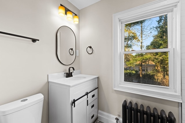 bathroom with radiator heating unit, vanity, and toilet