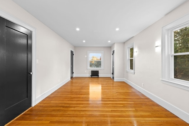 interior space with radiator heating unit and light hardwood / wood-style flooring