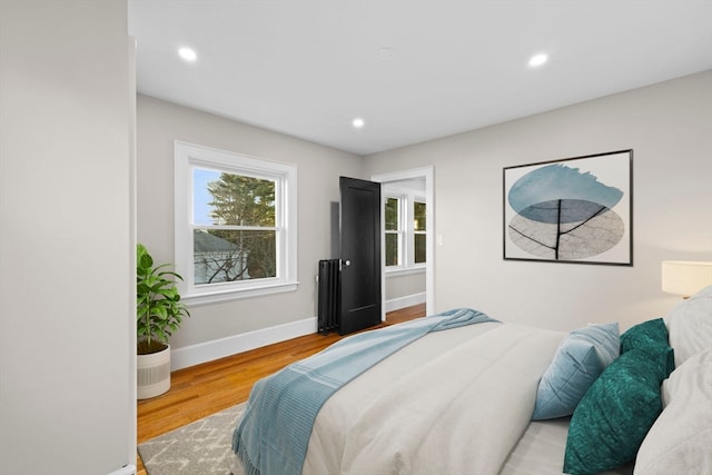 bedroom featuring radiator and hardwood / wood-style floors