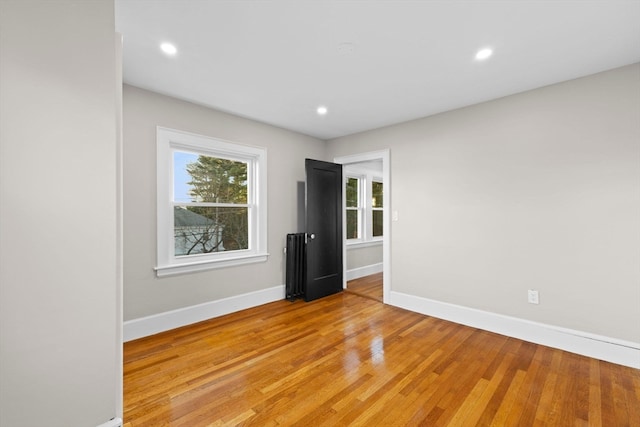 empty room featuring light wood-type flooring and radiator