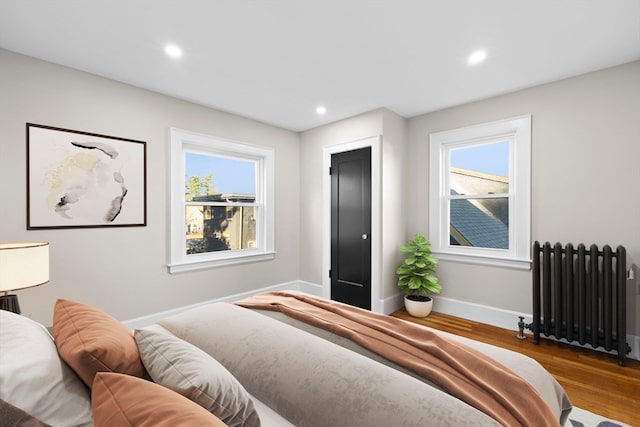 bedroom featuring wood-type flooring and radiator heating unit