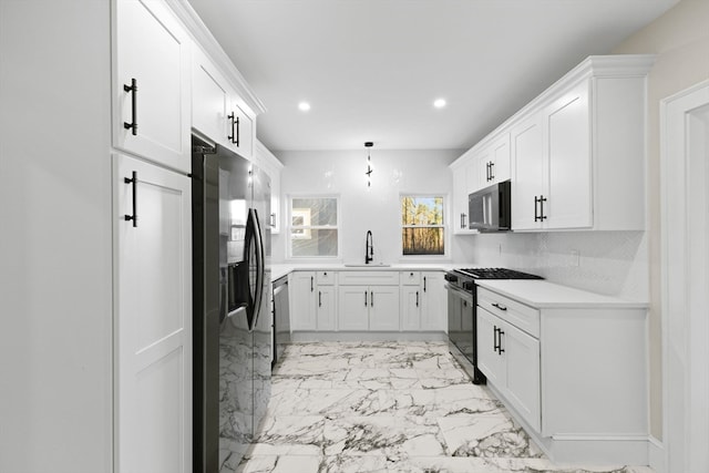 kitchen with hanging light fixtures, white cabinetry, sink, and appliances with stainless steel finishes