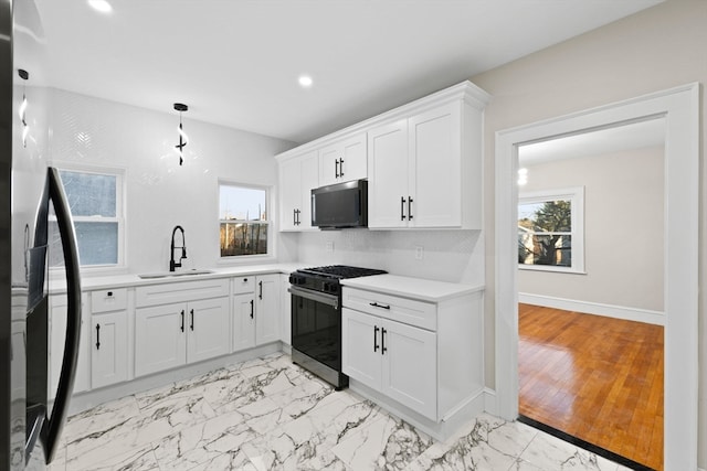 kitchen with white cabinetry, sink, stainless steel appliances, and light wood-type flooring