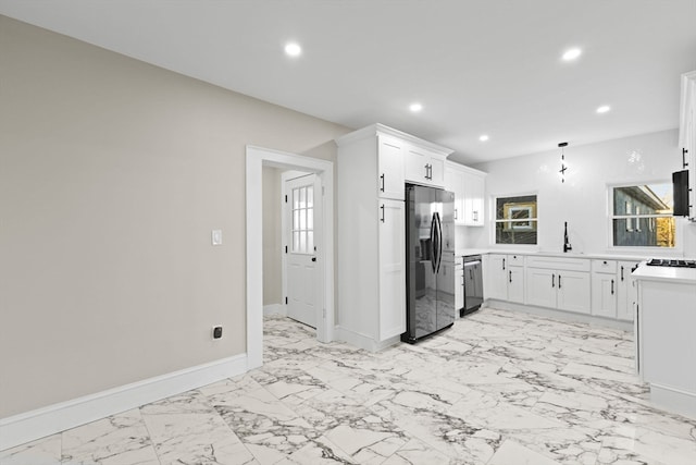 kitchen featuring white cabinets, appliances with stainless steel finishes, hanging light fixtures, and sink