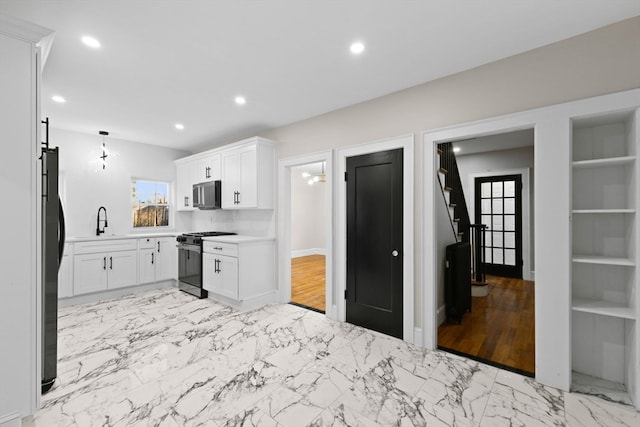 kitchen featuring white cabinets, sink, appliances with stainless steel finishes, and light hardwood / wood-style flooring