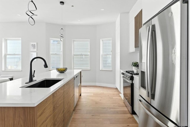 34 Woodford St Unit 2, Boston, MA 02125 - kitchen featuring stainless steel appliances, modern cabinets, brown cabinetry, light wood-style floors, and an island with sink