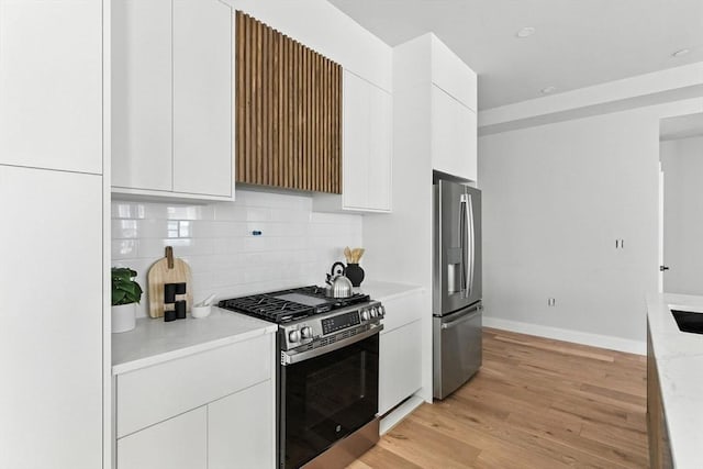 34 Woodford St Unit 2, Boston, MA 02125 - kitchen featuring stainless steel appliances, white cabinetry, backsplash, light wood-style flooring, and modern cabinets