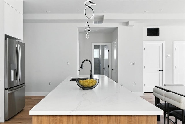 34 Woodford St Unit 2, Boston, MA 02125 - kitchen featuring stainless steel fridge with ice dispenser, a kitchen island with sink, light wood finished floors, modern cabinets, and light stone countertops