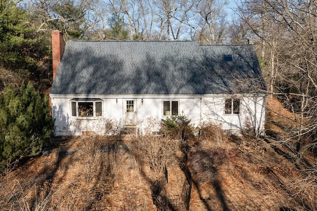 view of property exterior with a chimney and a shingled roof