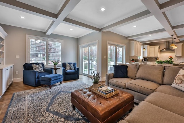 living room featuring light hardwood / wood-style floors, sink, beamed ceiling, crown molding, and coffered ceiling