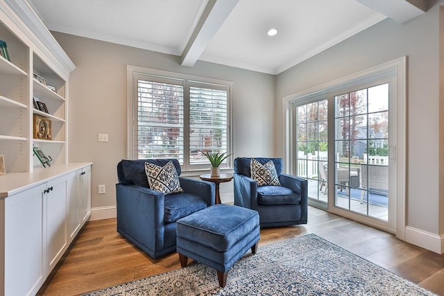 sitting room featuring plenty of natural light, beamed ceiling, and light wood-type flooring