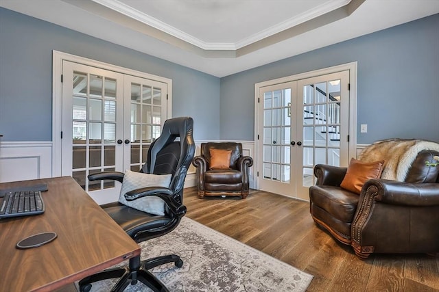 office space featuring hardwood / wood-style floors, a healthy amount of sunlight, french doors, and a tray ceiling