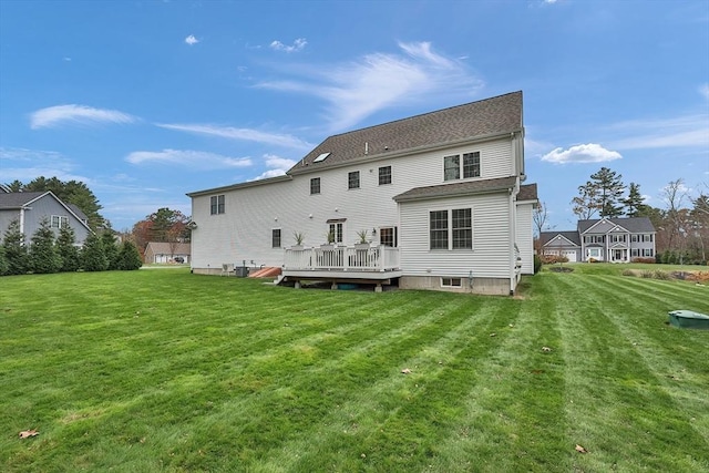 rear view of property with a wooden deck and a lawn