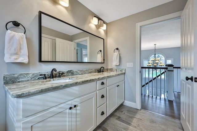 bathroom with vanity, a notable chandelier, and hardwood / wood-style flooring