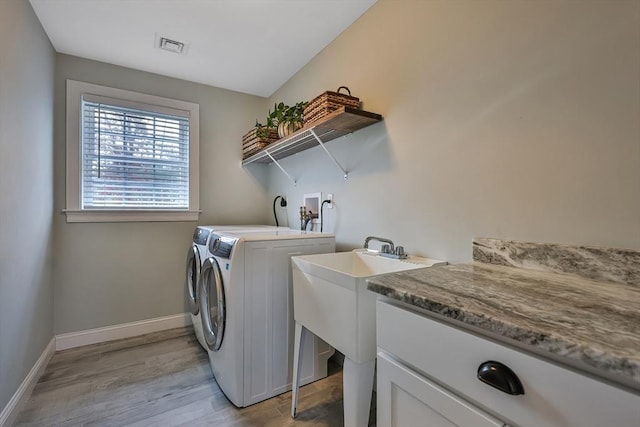 laundry room with light hardwood / wood-style flooring and washing machine and dryer