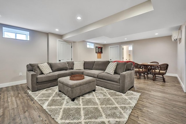 living room with wood-type flooring and a wall unit AC