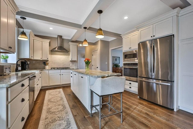 kitchen with backsplash, a center island, beamed ceiling, stainless steel appliances, and wall chimney exhaust hood