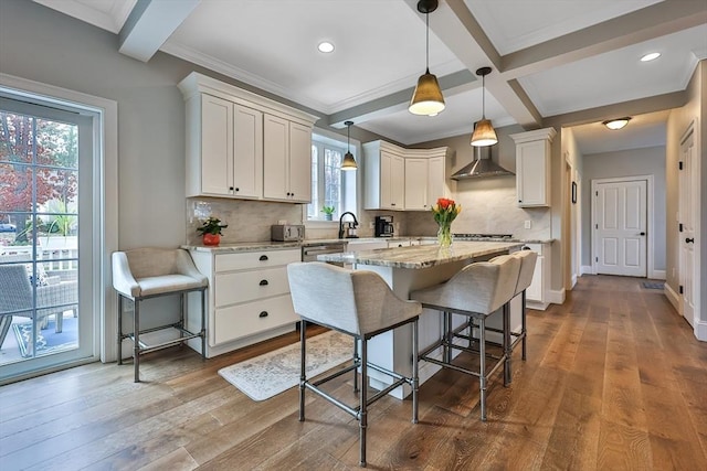 kitchen featuring a center island, decorative light fixtures, a kitchen bar, white cabinetry, and light hardwood / wood-style flooring