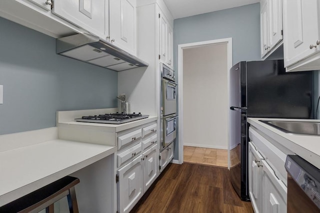 kitchen featuring white cabinetry, dark hardwood / wood-style flooring, and appliances with stainless steel finishes