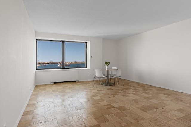 unfurnished room featuring radiator and a water view